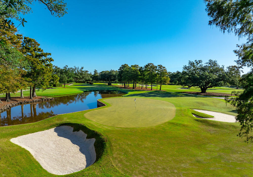 Water and bunkers strategically guard the green on the par three third hole.
